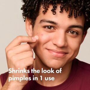 Young man applying Mighty Patch hydrocolloid acne sticker on pimple before bedtime skincare routine